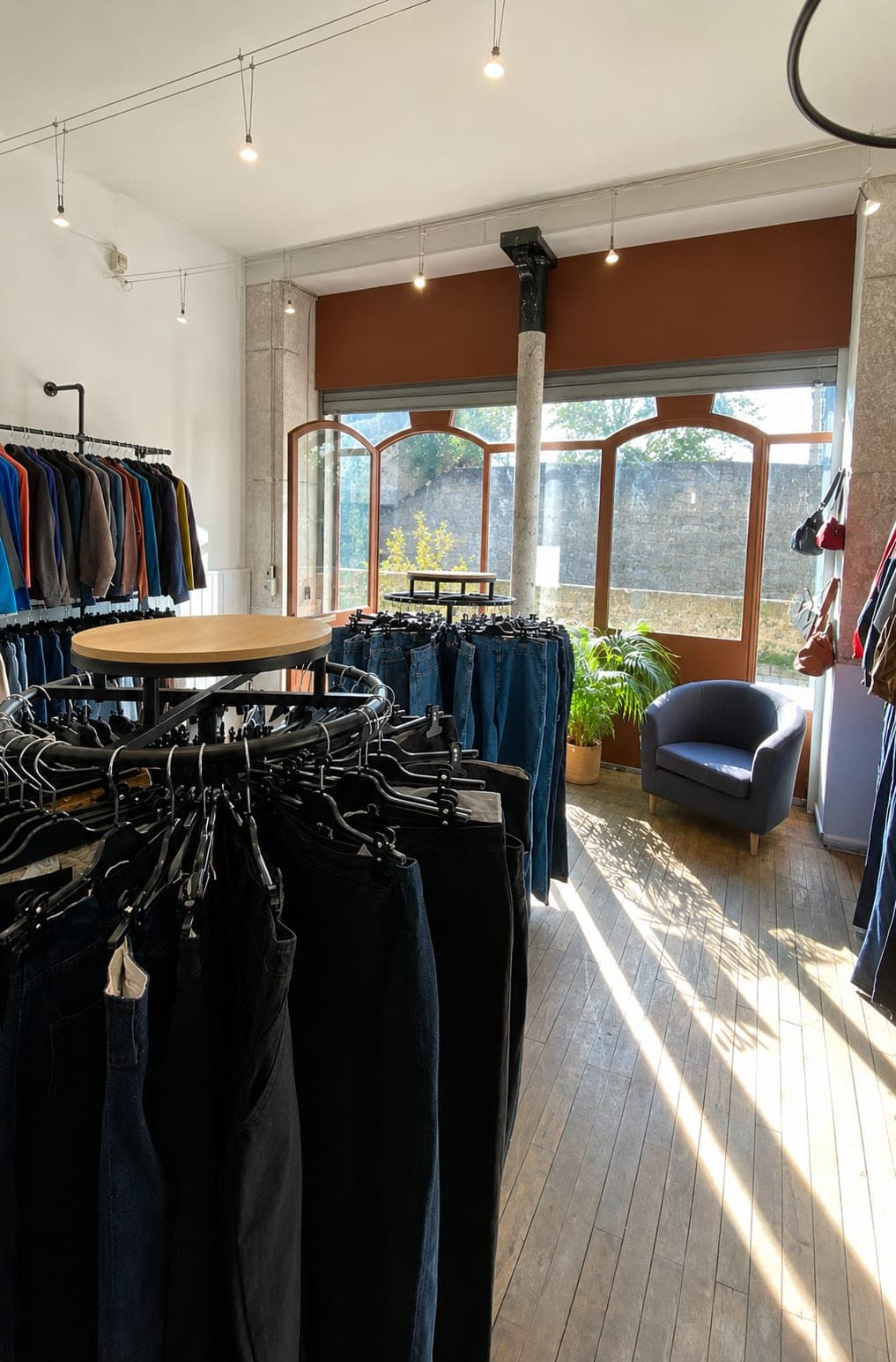 Sunlit interior of the Everywear shop: denim rails, jeans and lounge corner